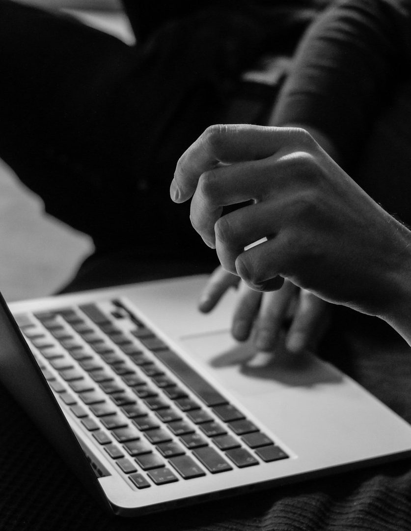 Kurse Eine Hand, die über die Tastatur eines Laptops tippt.
